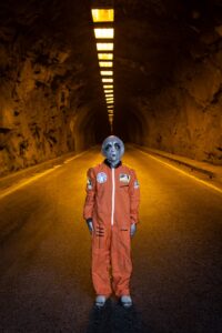 Person in astronaut costume standing in a dimly lit tunnel