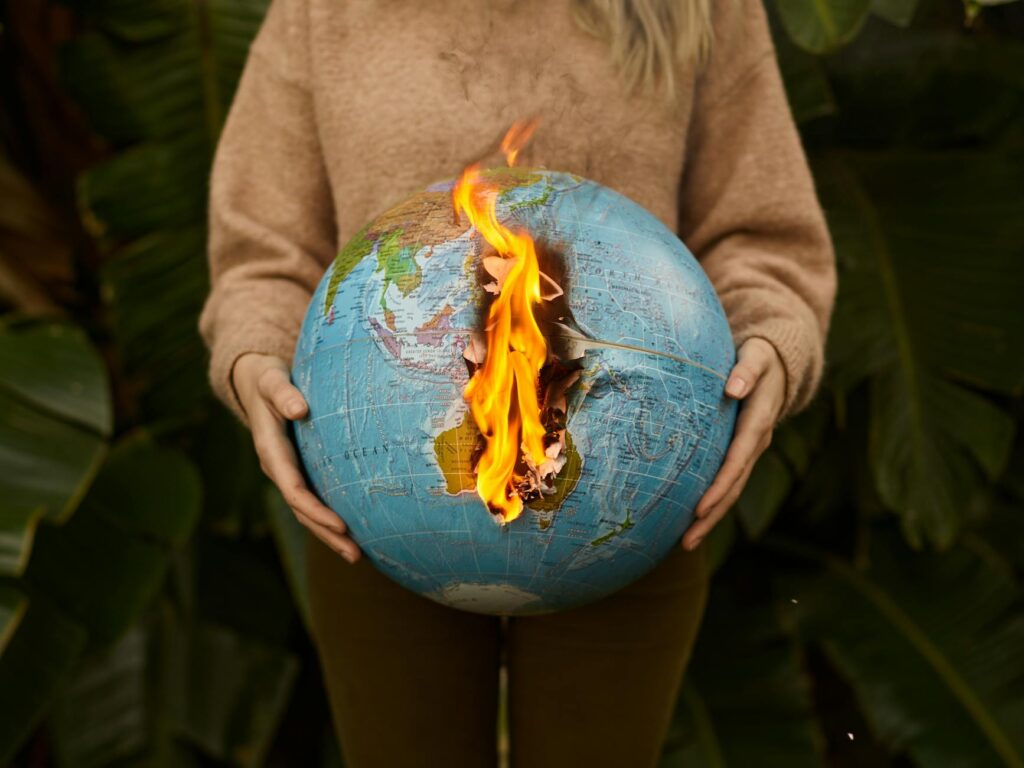 Person holding a burning globe symbolizing global crisis and (Incomplete: max_output_tokens)