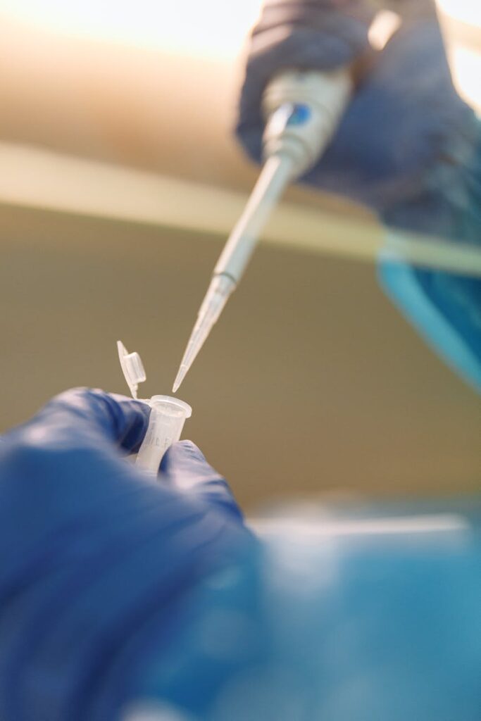 Scientist using pipette in genetics laboratory close-up