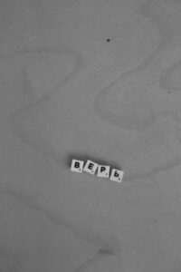 Black and white letter tiles spelling "BEEP" on a textured surface