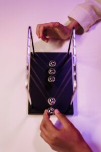 Person demonstrating physics with a Newton’s cradle desk toy in an indoor setting