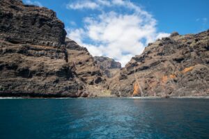 Rocky cliffs towering over clear blue ocean under a partly (Incomplete: max_output_tokens)